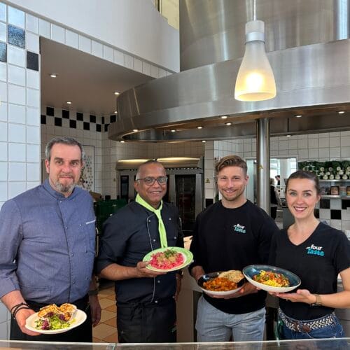 apetito catering Mitarbeiter präsentieren Tempeh-Gerichte in einer Großküche.