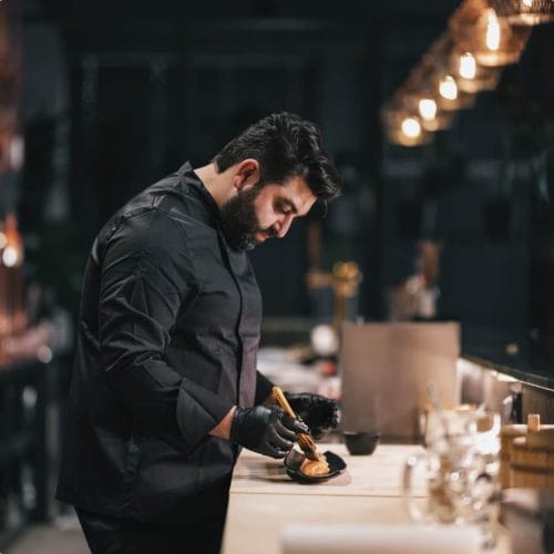 Koch Arsen Agadschanjan bereitet Speisen zu, zeigt kulinarische Expertise in der Küche