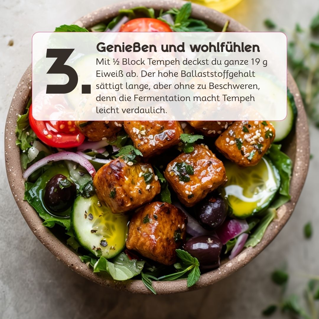 Mediterrane Tempeh Bowl mit Gurke, Tomaten, roten Zwiebeln und Oliven. Die goldbraun gebratenen Tempehwürfel werden mit frischen Kräutern und Gemüse serviert.