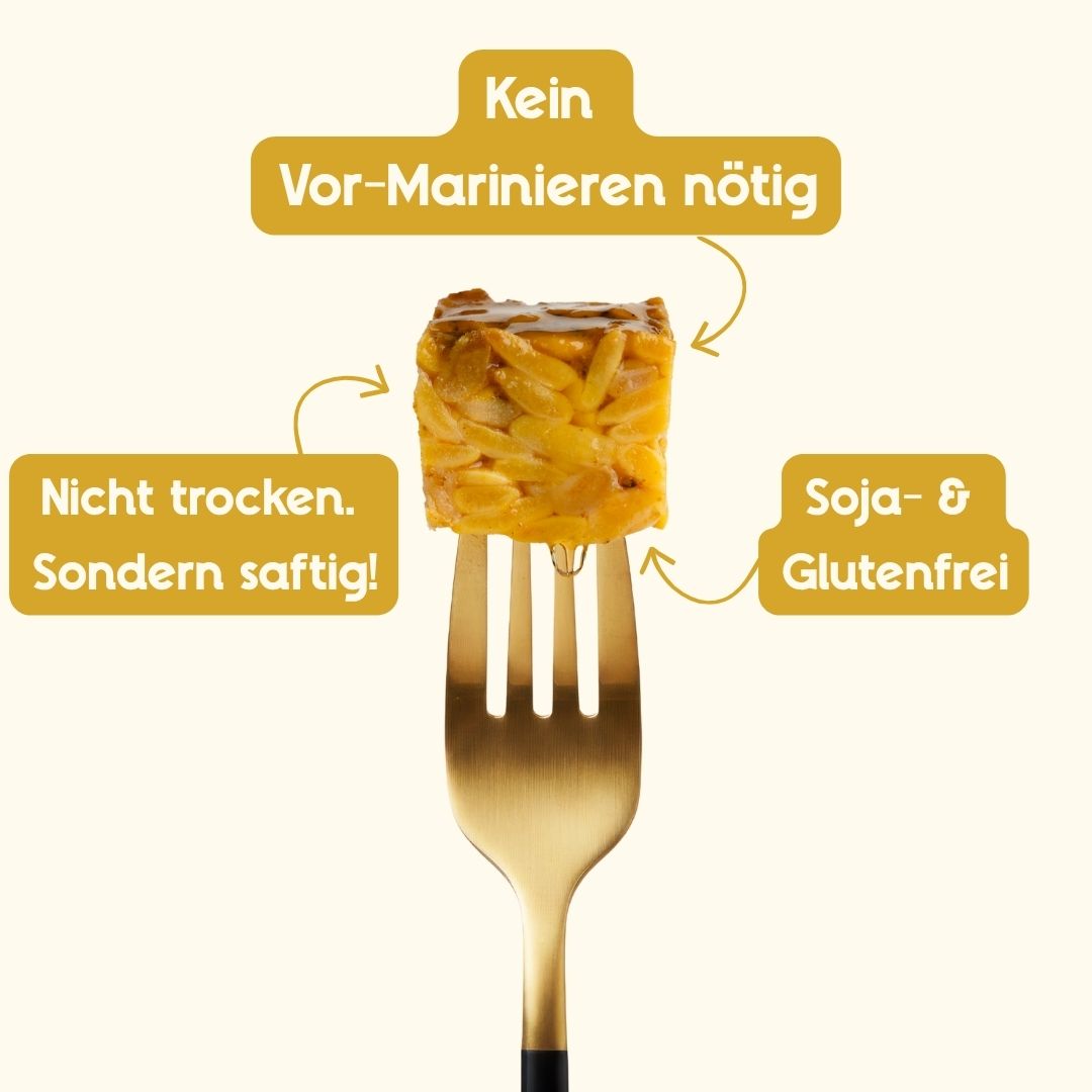 Ein mediterran mariniertes Stück Tempeh auf einer goldenen Gabel; Text-Hinweise markieren es als nicht trocken sondern saftig, soja- und glutenfrei sowie aus Hülsenfrüchten hergestellt.