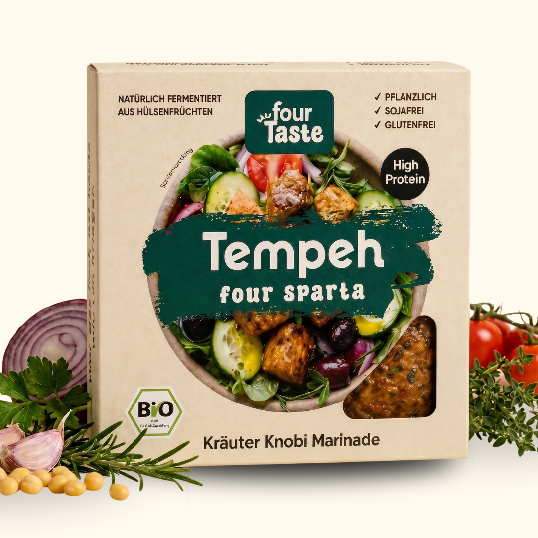 Verpackung des fourTaste Tempeh four sparta mit Kräuter-Knobi-Marinade. Der fermentierte Bio-Tempeh aus Hülsenfrüchten ist pflanzlich, sojafrei und glutenfrei. Rund um die Verpackung liegen Kräuter, Knoblauch und rote Zwiebeln.