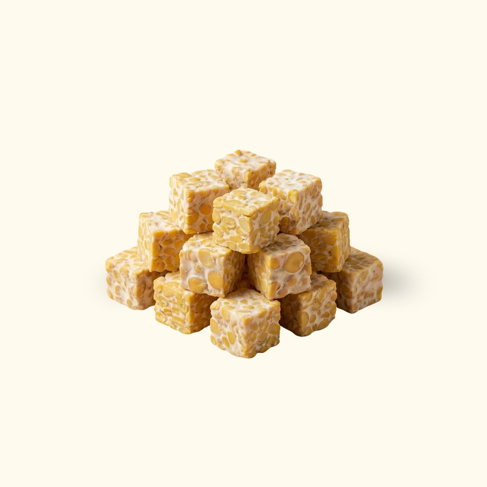 Gleichmäßig geschnittene, gewürfelte Tempeh-Stücke in einem Stapel für die Gastronomie.