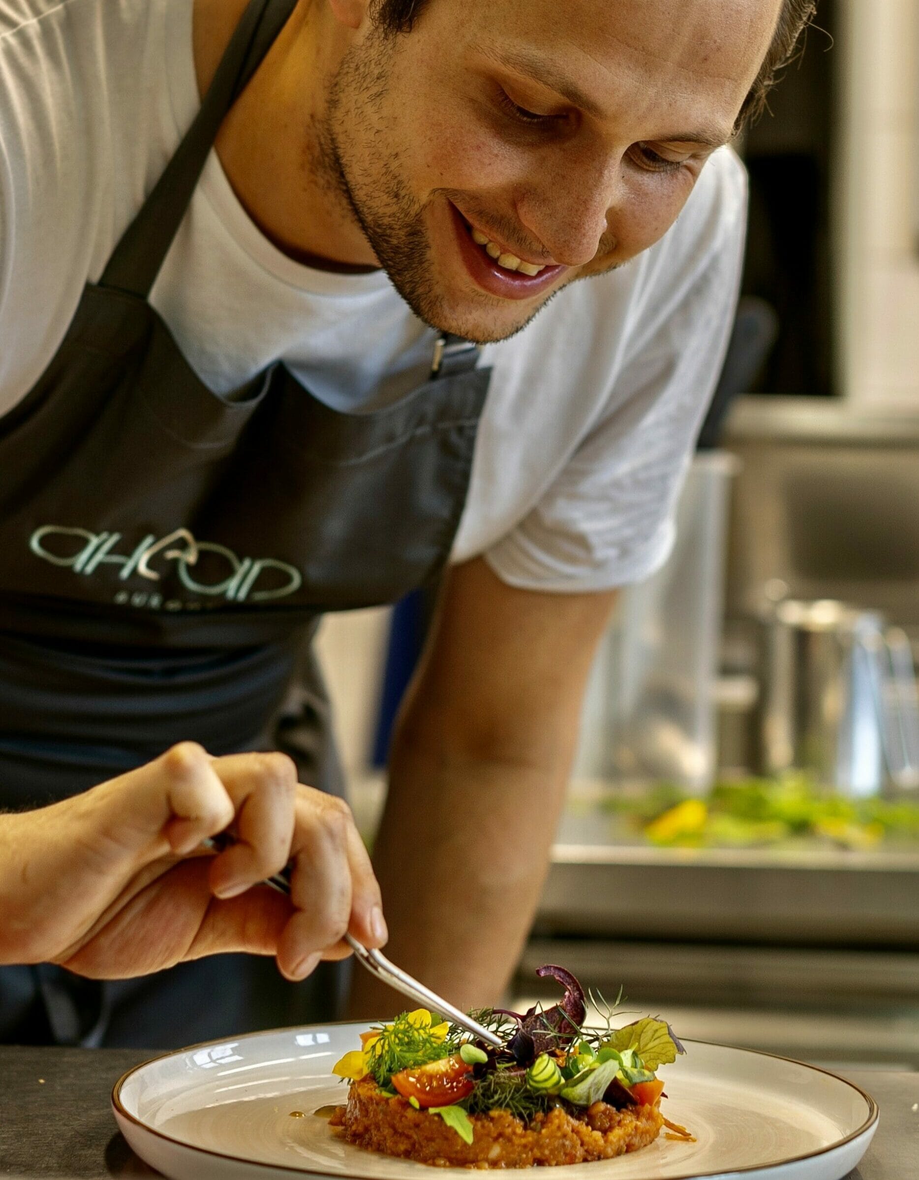 Jonathan Gebhardt vom ahead Hotel garniert einen Teller mit Tempeh.